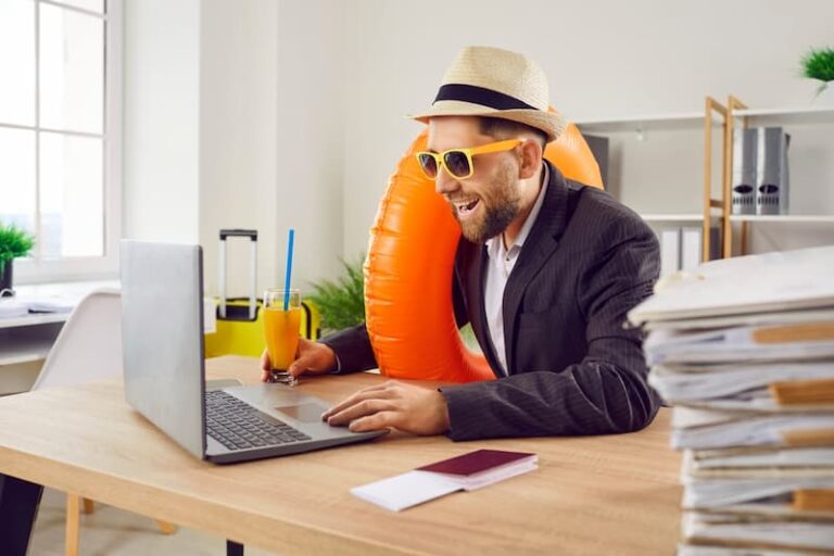 Ein Mann sitzt in Urlaubskleidung im Büro, ist Arbeiten im Urlaub erlaubt?