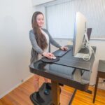 Eine Frau an einem ergonomischen Schreibtisch, was ist ein leidensgerechter Arbeitsplatz?